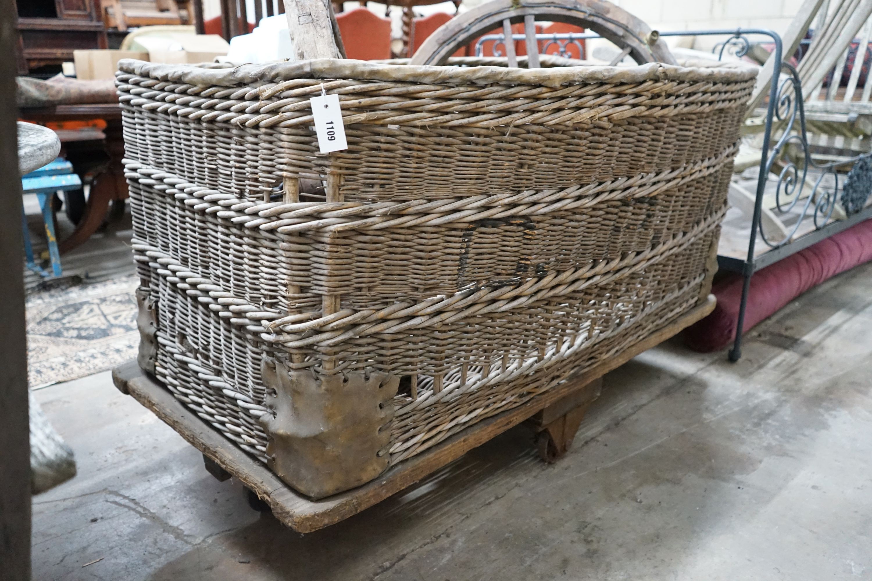 A large vintage wicker laundry basket on wheeled base, length 133cm, width 89cm, height 87cm